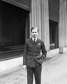 Informal three-quarter portrait of blond man in dark-coloured uniform, with a cigarette in one hand