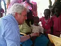 Stephen O'Brien meets a mother and her baby receiving medical treatment at a health centre in Jamam, South Sudan