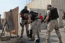 Crew members from a U.S. Coast Guard LEDET practice exothermal breaching techniques