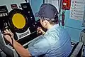 A crewman monitors a mine detection and classification console aboard the ocean minesweeper USS Conquest