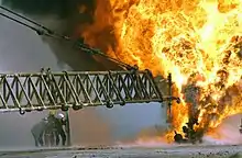 Firefighters fight to secure a burning oil well in the Iraqi Rumaila oilfields in 2003.