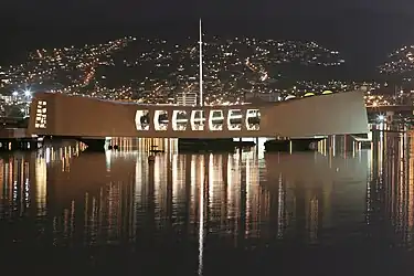 USS Arizona Memorial is bathed by the lights of ‘Aiea on the evening of the 62nd anniversary of the attack on Pearl Harbor, December 7, 2003.