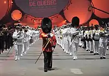 The United States Navy Band along with La Musique du Royal 22e Régiment, marches off during the closing ceremony of the Quebec Tattoo at the Pepsi Coliseum, 27 August 2009.