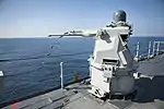 Mk 38 MOD 2 25mm autocannon gun system aboard the amphibious dock landing ship USS Pearl Harbor forward ejecting the spent casings.