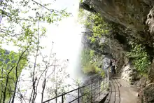 Photograph of a trail under a waterfall