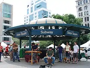 An entrance to the 14th Street-Union Square station within Union Square Park. The entrance is covered by a domed canopy.