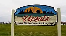 colorfully painted welcome sign reading "Upsala: where life is always looking up!"