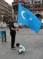 Uyghur man with Kökbayraq flag in Munich, Germany