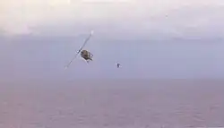 RVNAF pilot jumps from his Huey after dropping evacuees on USS Midway