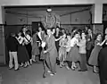 High school prom including a male (center) wearing Teddy Boy style suit with bootlace tie, 1956.