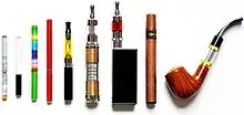 Displaying a variety of e-cigarettes standing next to each other. It includes an e-cigarette designed to look like a tobacco cigarette, an e-cigar, and an e-pipe.