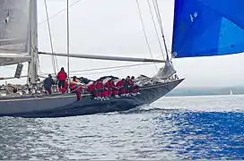 Velsheda under sail - crew are sitting on the gunwale.