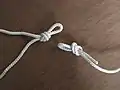 Make a loop knot on one end of the rope and another loop knot in the middle, just shorter than the area to be bound. (An overhand loop knot can be used here, but a Butterfly Knot works better because it doesn't jam when strained and it's easy to untie.)