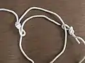 Bring the second working end up through the loop knot tied in the middle of the rope.