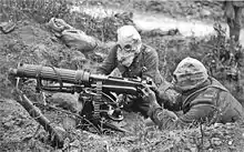 English: British Vickers machine gun crew wearing PH-type anti-gas helmets. Near Ovillers during the Battle of the Somme, July 1916. The gunner is wearing a padded waistcoat, enabling him to carry the machine gun barrel.