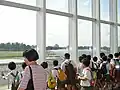 The viewing gallery of Singapore Youth Flying Club overlooking the runway of Seletar. Note the club's Piper Warrior taxiing on the runway.