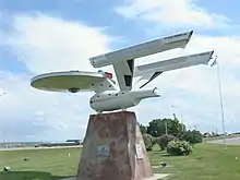 A roadside replica starship atop a stone base