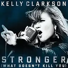A blue-tint-in-a-black-and-white image of a woman singing. Her right hand is holding a vintage carbon microphone in front of her mouth. The microphone's wire is resting on her left hand between her thumb and her index finger. Below her, the words "Stronger" and "(What Doesn't Kill You)" are written in white upper-case letters.