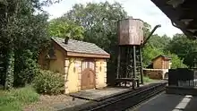 A water tower and two storage buildings adjacent to railroad track