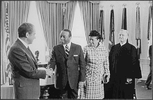 President Nixon shakes hands with Walter Washington, while Bennetta Bullock Washington and Edward A. Tamm look on. 1973, Oval Office, White House.