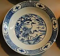 A typical design centering on water birds, outline and wash in cobalt blue.