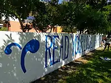 The logo of The Student Life and a "read your local newspaper" message, painted in blue against a white background on Walker Wall