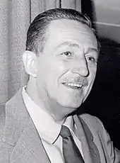 A black and white headshot of a caucasian male wearing a suit, whose hair is neatly combed back, with a small mustache.