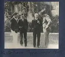 Monochrome photograph of Anthony Asquith and friends standing in a garden