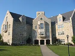 A 4-story stone building, with an asphalt walkway leading to a large entrance area
