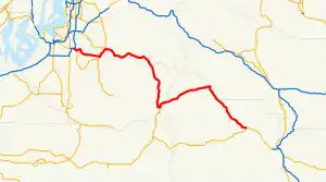 A map of the Cascade Range northeast of Mount Rainier and the surrounding foothills depicting the route of State Route 410 (SR 410, highlighted in red) between Sumner at SR 167 and Naches at U.S. Route 12 (US 12). This was one of the sections that made up US 410, which existed from 1926 until 1967, being replaced with US 12.