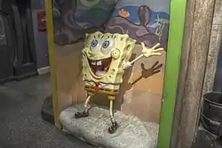 SpongeBob SquarePants wax statue with its left arm raised and a big smile on its face