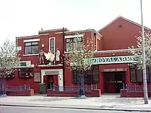 Red brick building by roadside with life size figures of John Wayne, Marilyn Monroe and Humphrey Bogart and on high above doorway