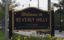 Black sign with gold lettering that says "Welcome to Beverly Hills / City of Chicago / 95th Street Beverly Hills Business Association".