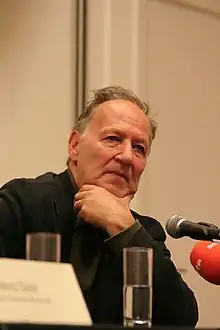 Herzog speaking before a microphone in 2007
