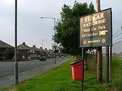 An image of a road with houses beyond