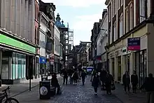 A pedstrianised street with banners stretching between the buildings on both sides