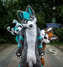 Three people dressed in fursuits, representative of their respective fursona.