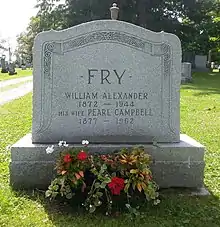Grey granite stone inscribed with Fry's details, adorned with two vases of flowers