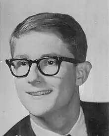 Photo of William Woods' face in 1967. He has glasses, short slicked-back hair, and no facial hair; he is wearing a suit.