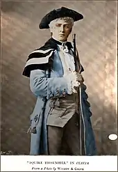 Terriss, in 18th-century costume, holding a rifle