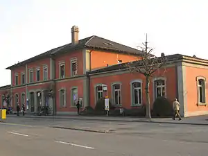 Two-story building with hip roof and single-story wings