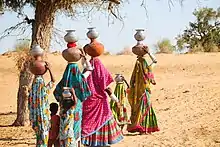 Women with children returning home after fetching water