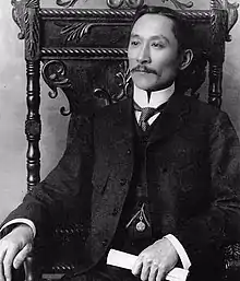 Won Alexander Cumyow as a young man with a handlebar moustache, dressed in a Western suit.