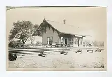 A small train station next to several train tracks.