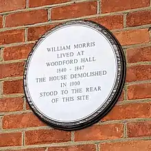 Plaque reading "William Morris lived at Woodford Hall 1840-1847. The house demolished in 1900 stood to the rear of this site."