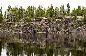 A rock wall at the edge of a body of water.