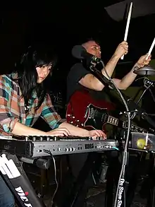 Angela Seo (left) and Jamie Stewart (right) performing with Xiu Xiu in 2010