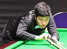 Picture of Yan Bingtao playing a shot with a rest.