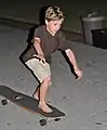Young skater pushing his hybrid longboard