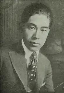 A Japanese man, dark hair brushed back from forehead, wearing a suit and tie, from a 1919 photo